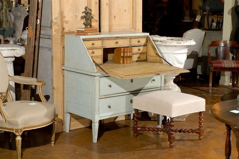 Painted writing desk with slant front and multiple drawers.