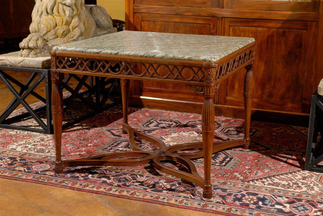 An Italian square marble top and carved walnut center table with baluster legs and cross stretcher from the early 19th century. This Italian center table circa 1820 features an uncommon veined marble top of square shape over a carved walnut base.