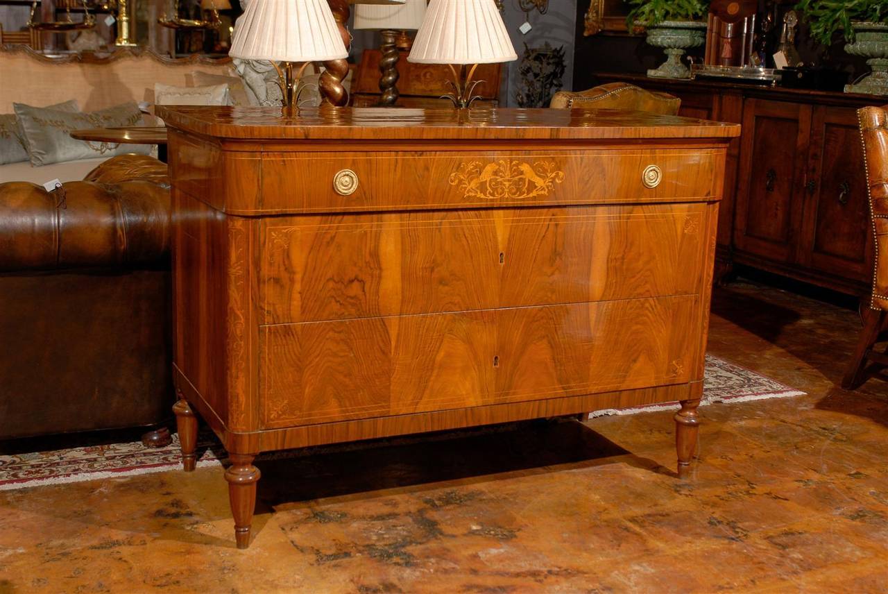 A pair of Tuscan Neoclassical marquetry three-drawer commodes from the mid 19th century. Previous possessions of a prominent Florentine family estate, each of these walnut veneered over poplar chests features a rectangular top with rounded edges in