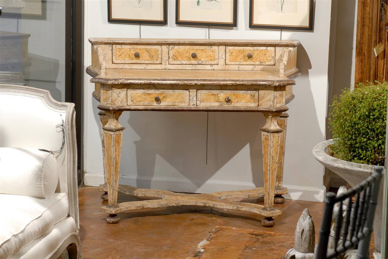 A Florentine Baroque style faux-marble yellow painted desk. This Italian marbleized desk was born in Florence,  The desk is painted in two exquisite shades of soft yellow. The writing section is flanked with Baroque style volutes terminating with