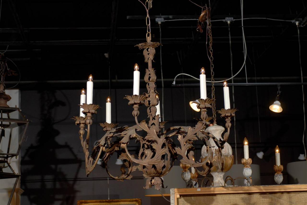 An Italian eight-light wrought-iron chandelier with scrolling acanthus leaves from the late 19th century. This stately Italian chandelier from the 1890s features a central foliate column evolving into a bulb, from which eight exquisite arms emanate.