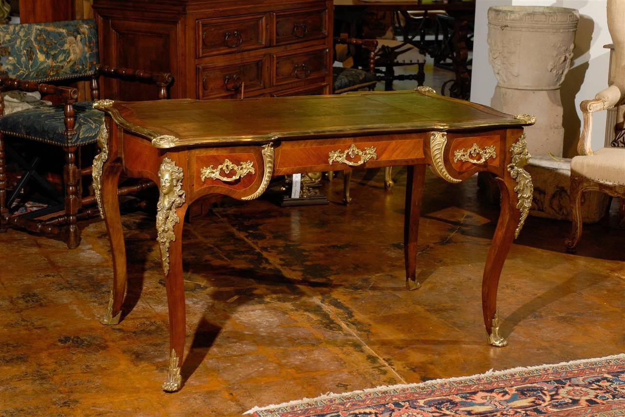 Antique French marquetry desk with three drawers in Acajou (the wood of any of several species of mahogany) and elegant bronze hardware, circa 1880.