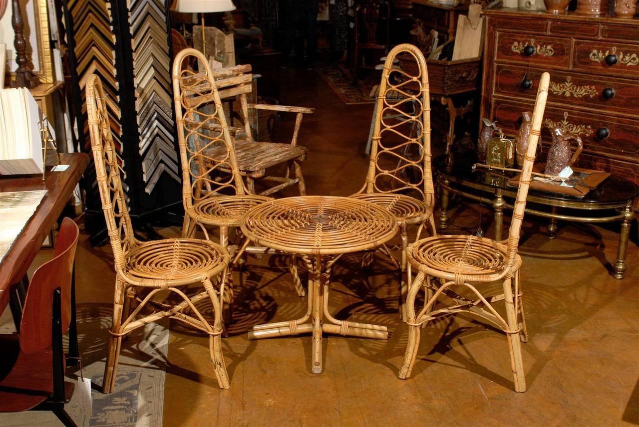 Vintage French rattan table and four chairs, all carved with scrolling motifs.
Dimensions: Chairs 17" W x 16" x 43" H x 16" seat H.
Table 23" diameter x 20" high.