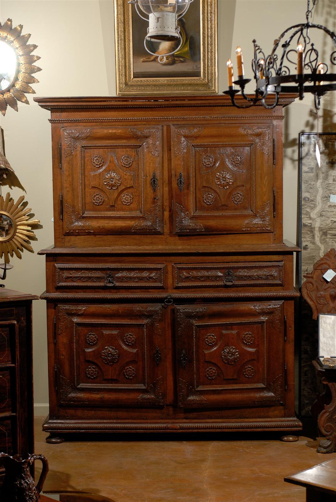 Early 17th century French walnut buffet a deux corps, the corniced top surmounting two doors, opening to reveal two shelves on the left and one on the right, above two drawers and a slide out writing surface, all above a double door cabinet opening