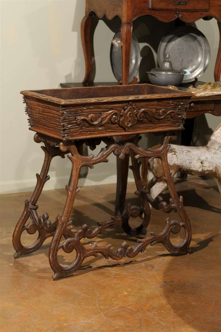 19th century Black Forest jardiniere, the tapering rectangular box surmounted by a curved apron and raised on two scrolling side legs, each joined by a central stretcher, with original zinc liner. 