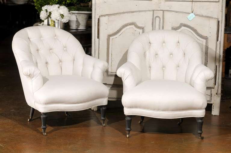 Lovely and comfortable pair of petite armchairs with tufted backs on casters..  Newly upholstered.