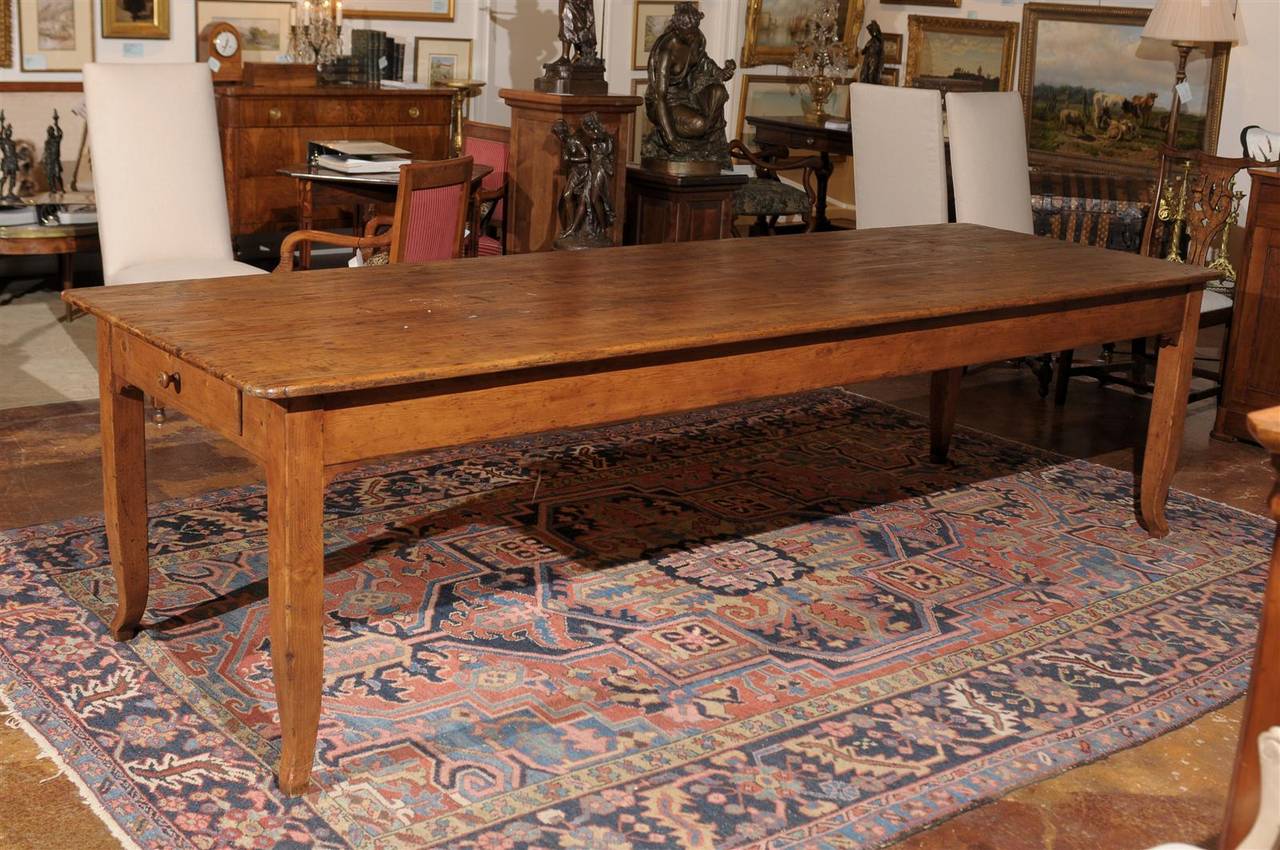Late 19th century Italian pine farm table, the rectangular top surmounting a drawer on either side and raised on curved legs.