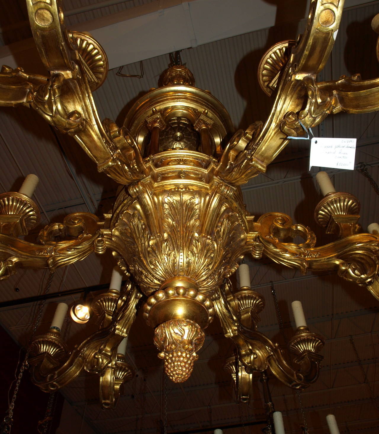 Incredible hand carved Russian gilded wood chandelier with architectural central form featuring neoclassical columns and having 18 lights, in a monumental scale.