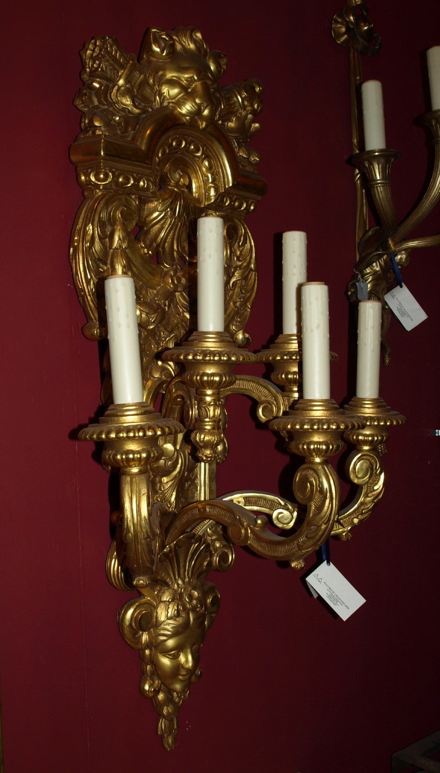 Pareja de opulentos y extraordinarios apliques de madera dorada tallada a mano de estilo Regencia con cinco luces electrificadas, con una máscara femenina en la parte inferior y de león en la superior, dos parejas disponibles