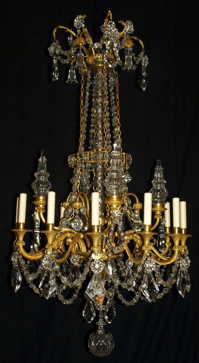Superb gilt bronze and crystal chandelier with exquisite detail in the Louis Phillip style featuring four illuminated crystal pyramids and hand cut crystal pendalogues.