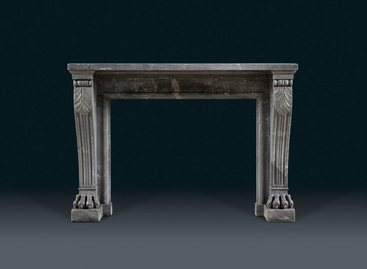 Of bold and masculine design, the broad mantelpiece above a recessed aperture flanked by scrolling acanthus carved reeded monopodium jambs with lion's paw feet French, circa 1830.