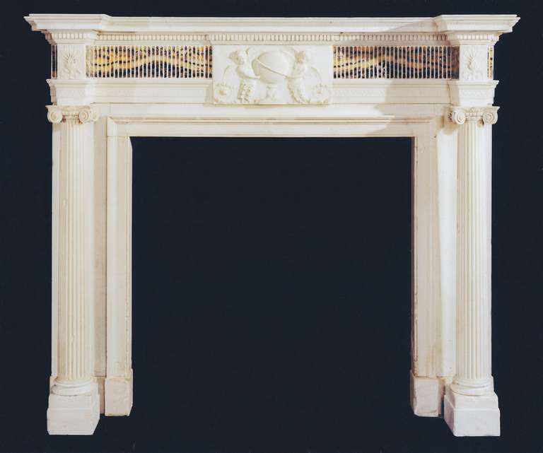 With detached fluted columns terminating in ionic capitals, beneath corner blockings carved with anthemions. The chimneypiece has a center tablet that closely resembles that by Robert Adam in the library at Kenwood House
and this chimneypiece