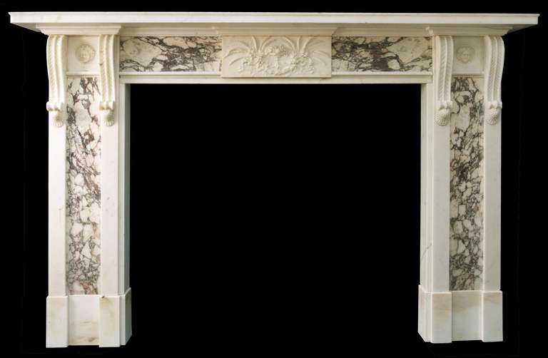 carved in statuary marble with panels of Breche marble in the jambs and frieze. Details include a finely carved central tablet and delicately carved twin corbels flanking panels inset with female masks.