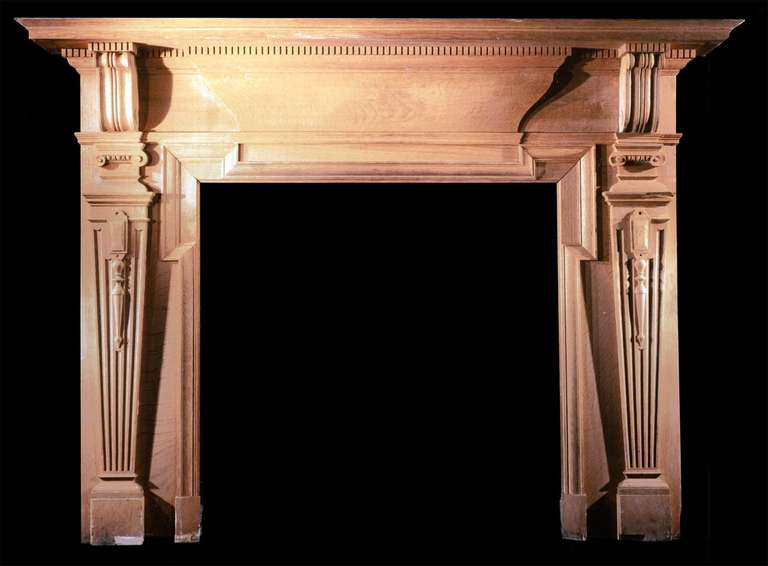 With tapering fluted pilasters and a blank frieze.