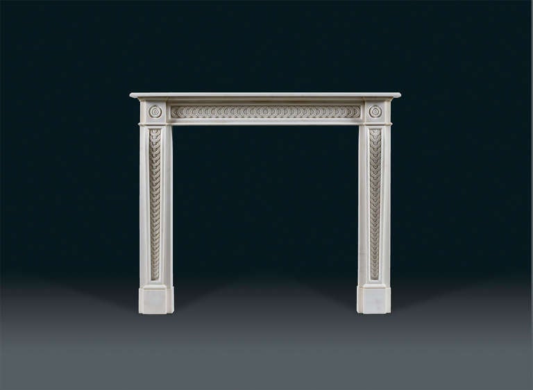 The square blocks of this finely carved chimneypiece support console shaped jambs decorated with overlapping guilloche, also repeated on the inset fielded frieze, while the projecting end blocks feature delicate circular paterae.