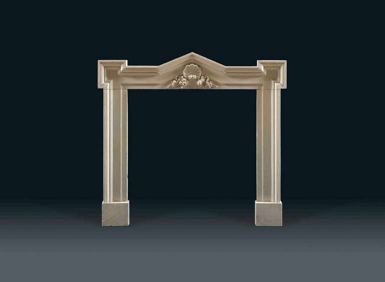 A Painswick stone 18th century chimneypiece with deeply moulded and rounded architectural lines the centre with rounded capped arch, above the frieze which is carved with an acanthus leaf and flowers.