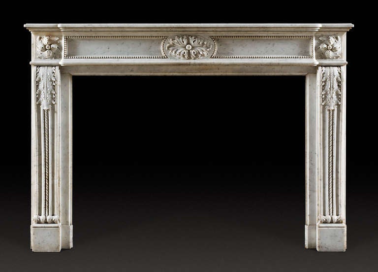The rectangular shelf above the frieze which is center decorated with an oval-shaped medallion carved with acanthus, flanked by inset panels framed by running pearl. The jambs in the form of scrolled consoles, decorated again with acanthus and