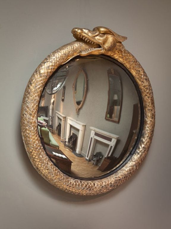 A superb Regency giltwood convex mirror, the frame depicting a scaled serpent eating its tale