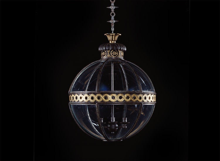 Each of the 12 glass panes sit within bronze mouldings divided by a meridian band of pierced gilt brass guilloche. The gadroon moulded chimney with flower head filled, gilt brass guilloche sits beneath a leaf cast rose.