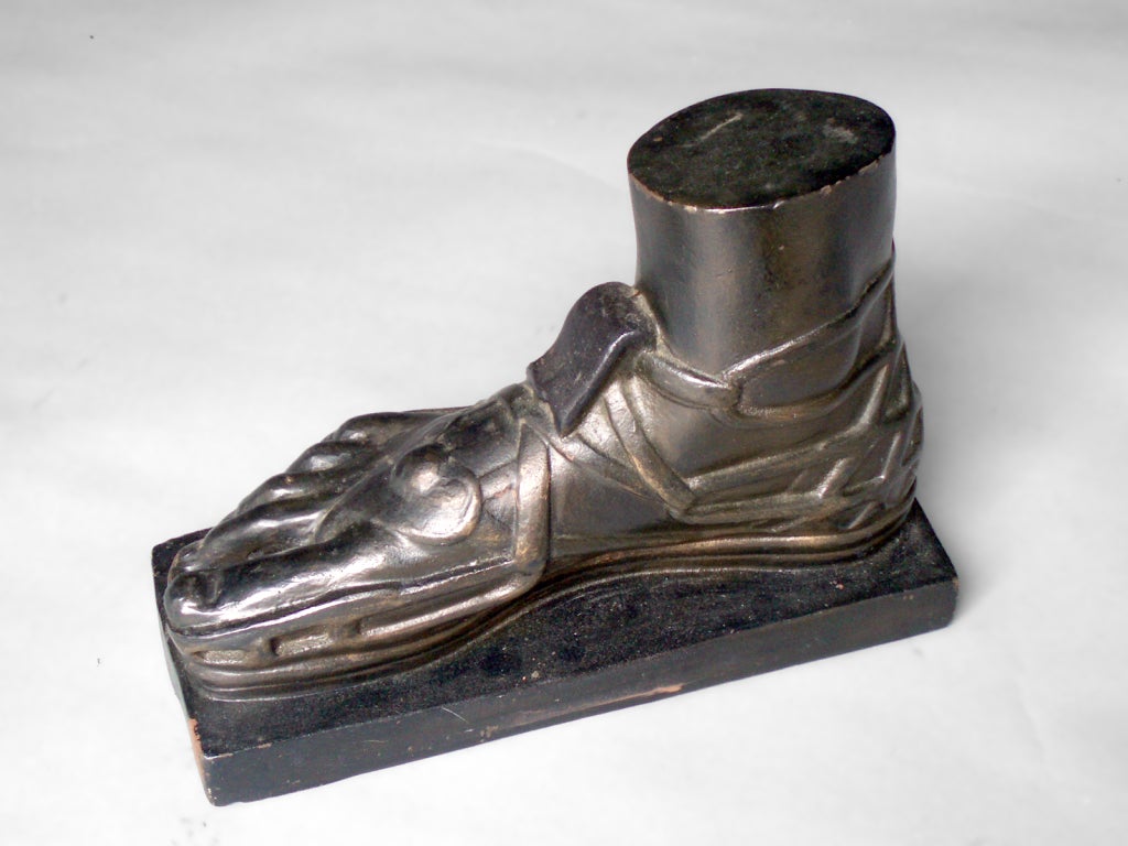 Early 20th century cast iron trade stimulator with cast iron foot with gladiator sandals.