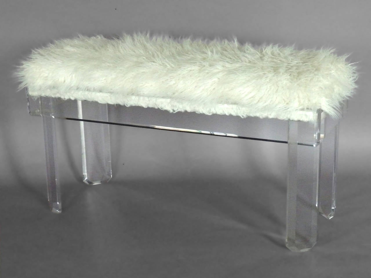 Substantial lucite frame with cushion covered in white faux fur .  Similar in style and design to a Charles Hollis Jones or Ritts piece . 