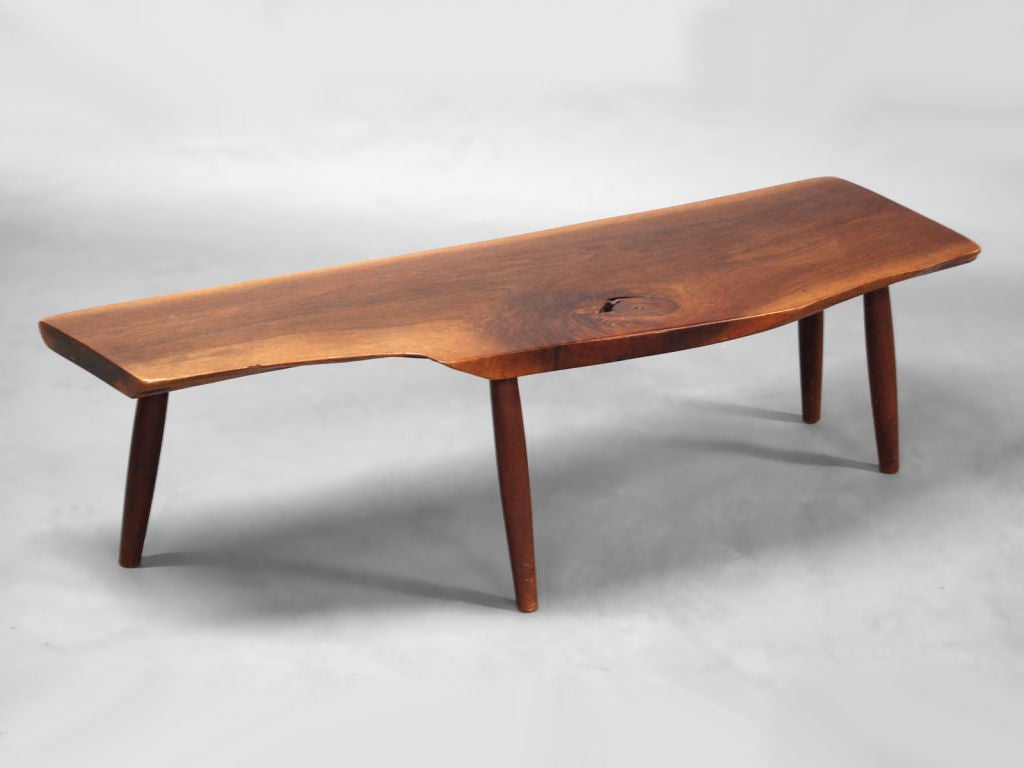 Hand crafted solid American black walnut slab coffee table in the manner of George Nakashima / New Hope School. Walnut slab with 4 tapered / splayed turned walnut legs. One leg offset to conform to the organic nature of the top. Table could also