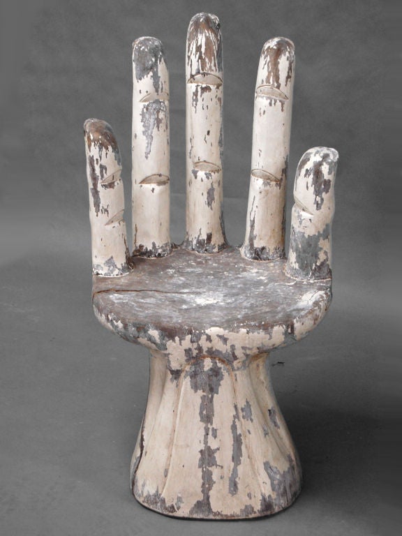 One hand carved folk art chair in the form of hands. Each chair carved from solid wood.