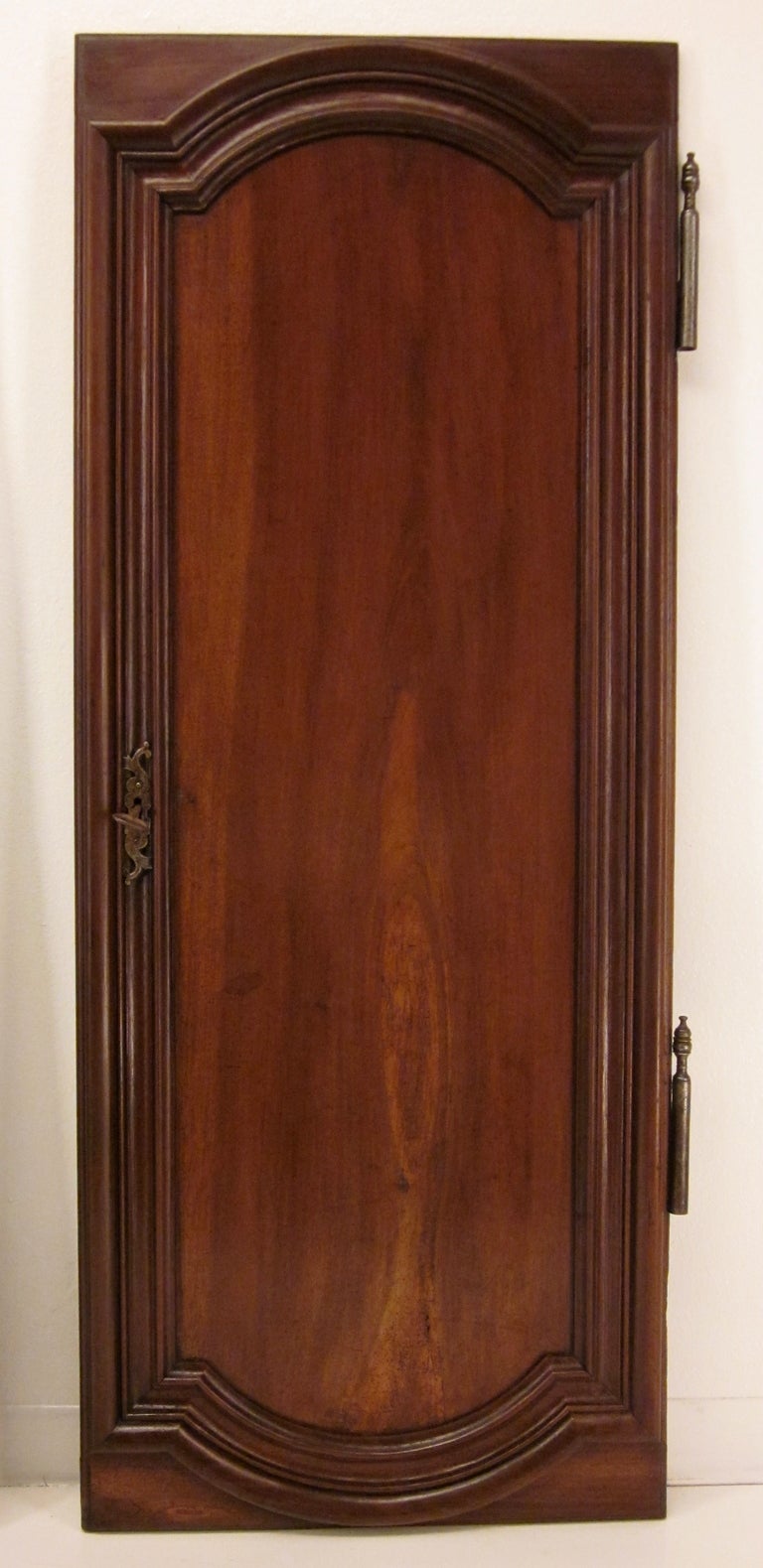 A pair of French Louis XIV style solid walnut doors with matching panels and thick molding. These doors were part of an armoire and have the original hardware hinges, lock and key. Waxed finish. 
More photos available upon request. We have a large