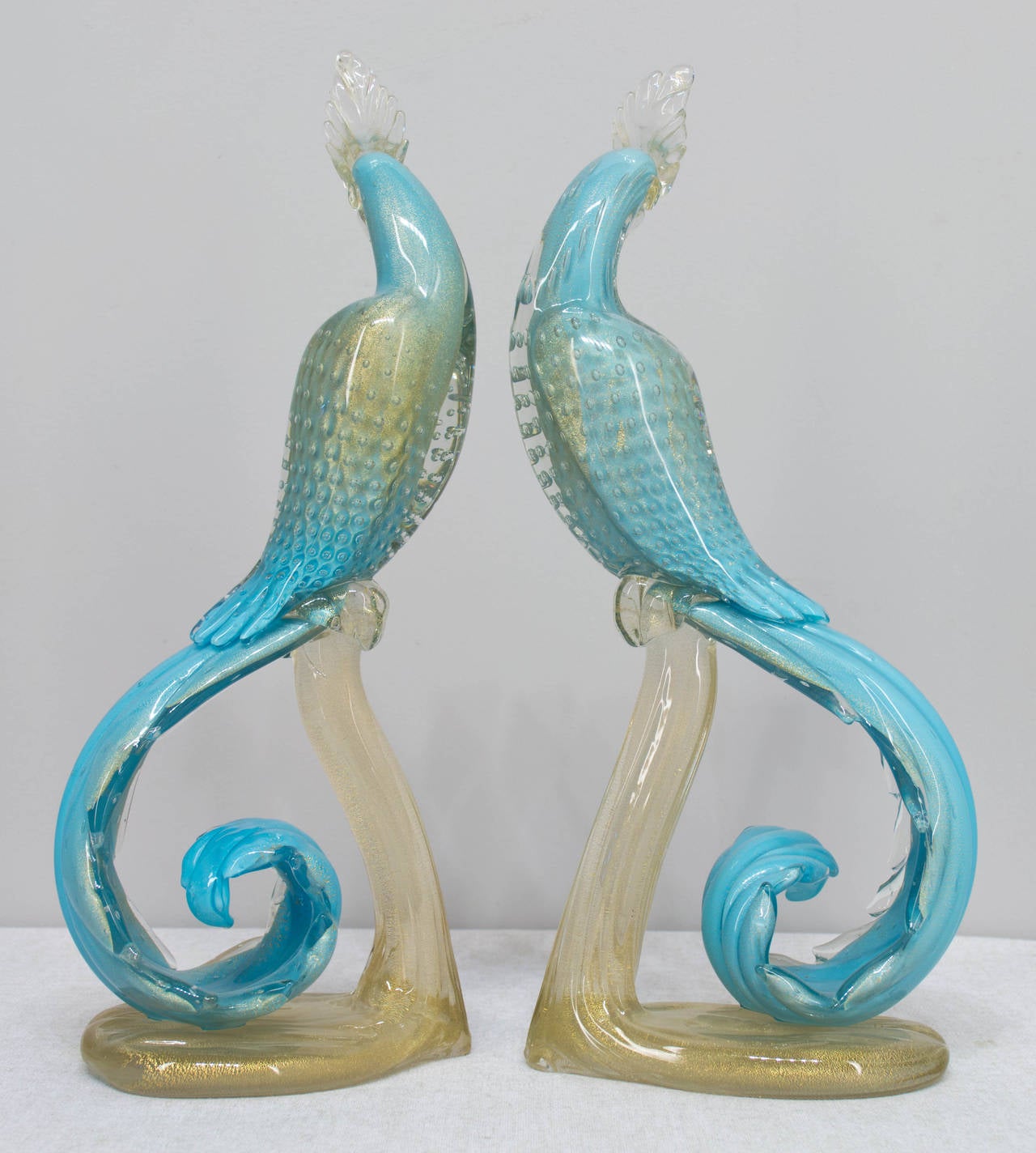 Rare pair of handblown Mid-Century Murano glass parrots by Alfredo Barbini, circa 1950. Beautiful light blue color with gold inclusions throughout and controlled bubbles on the body and wings. Tall, elegant curving form of the body and curl of the