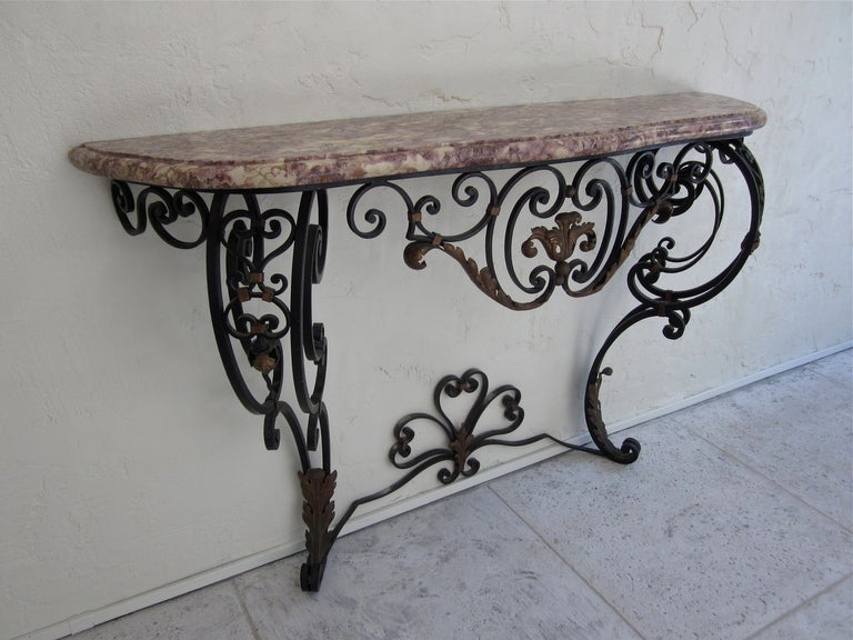 An early 20th Century Louis XV style wrought iron console from the South of France. Nicely crafted scrolling black iron with gilt detail and a shaped marble top. As always, more photos available upon request. We have a large selection of French