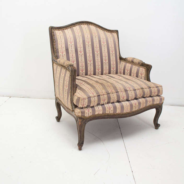 An original 18th century fauteuil made of beechwood retaining some old paint, pegged construction. In a need of new fabric. This type of chair was made for ladies and the voluminous dresses of the 18th c..
Good seating. inside measurements 24