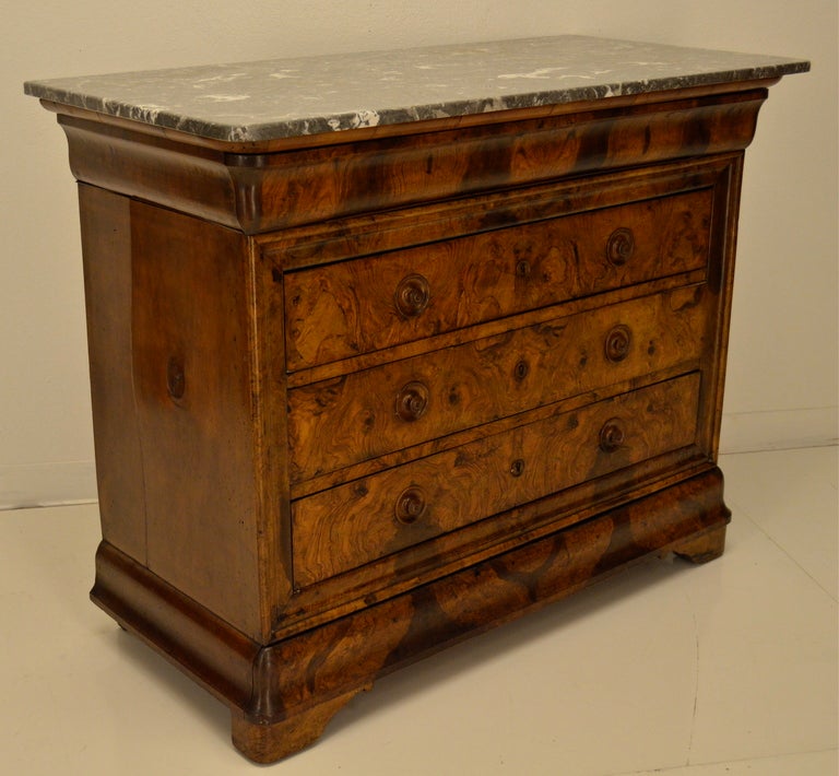 A five drawers commode made of burl of walnut and solid walnut (sides) with a St Anne Marble top (new). The inside of the drawers are lined with fabric.