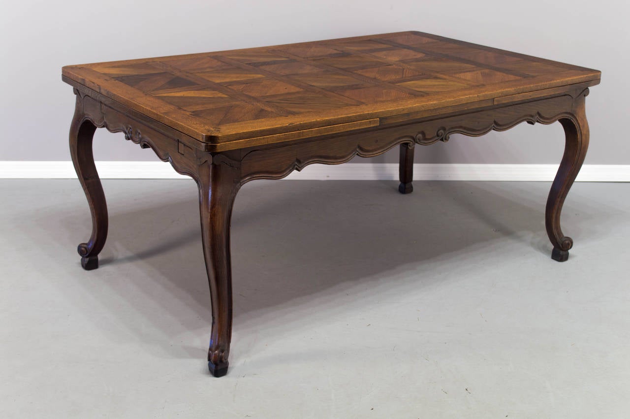 A 19th century solid oak refractory table, well constructed with mortise and tenons and pegged construction with two draw leaves on four curved legs ended by a scroll toe. Beautiful rich color with a tung oil finish to protect the wood for every day