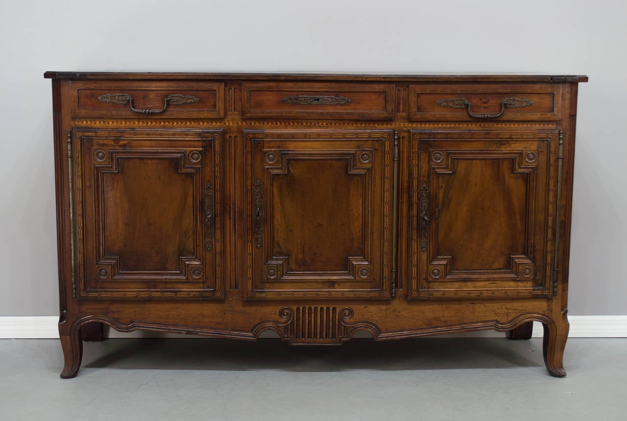 A 19th c. French Louis XVI Style Enfilade or Sideboard made of solid walnut with inlay, with three dovetailed drawers and three doors. Plenty of storage with one shelf on the inside, this enfilade has been restored in the middle of the 20th century.