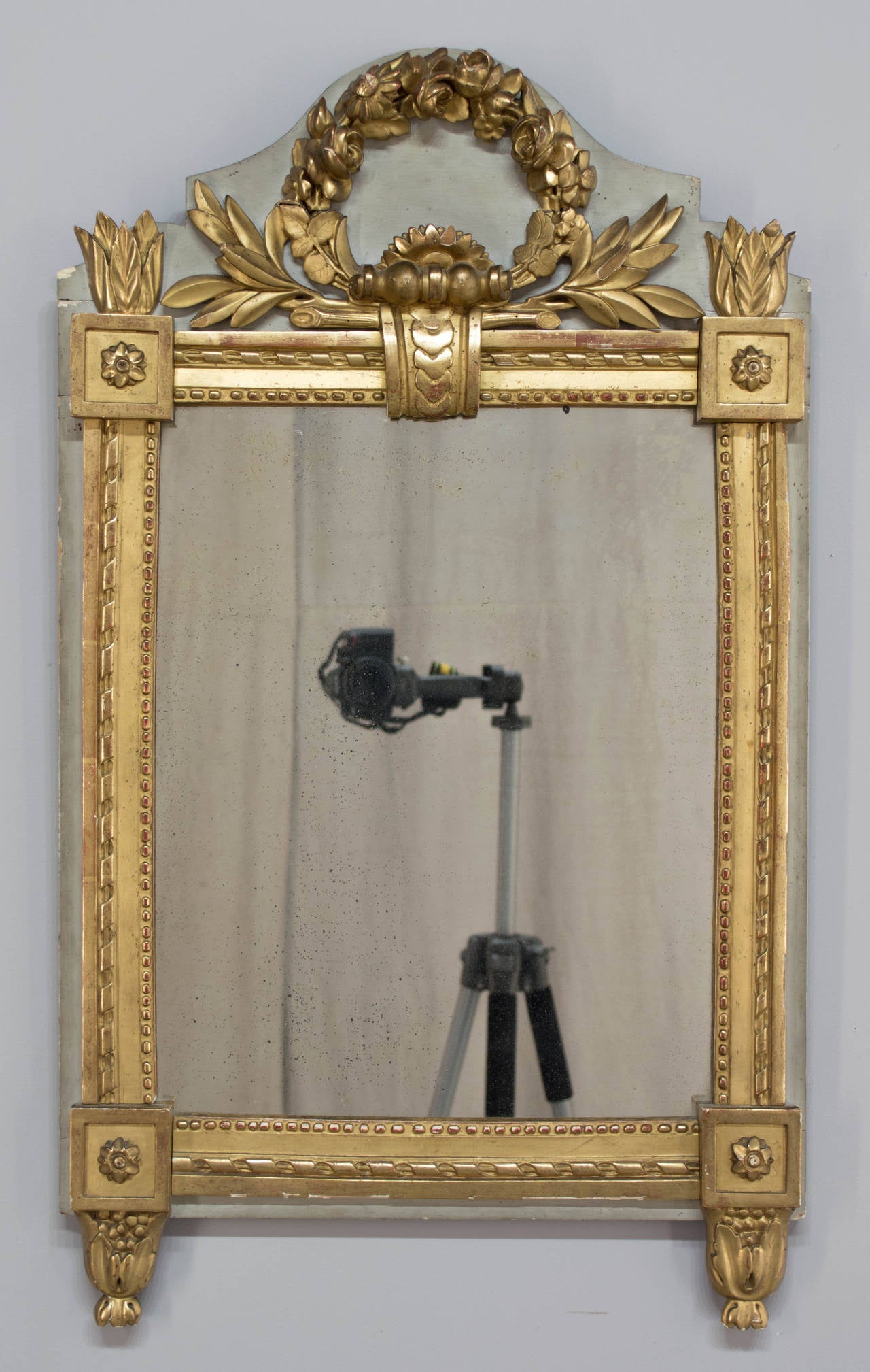 19th c. French Louis XVI style mirror. Nice carving of floral wreath and scroll in high relief, with rosettes at the corners. Gilt frame is over verdigris painted background panel. In very good condition with small paint loss on upper left corner
