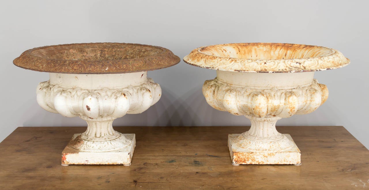 Pair of 19th century French cast iron urn planters with nice old weathered patina. Stamped with the name of the foundry on bottom: Ancienne Maison Godin, Bequennet & Cie., Guise-Aisne No. 25. Large in scale, weighing 45 pound each. Painted several
