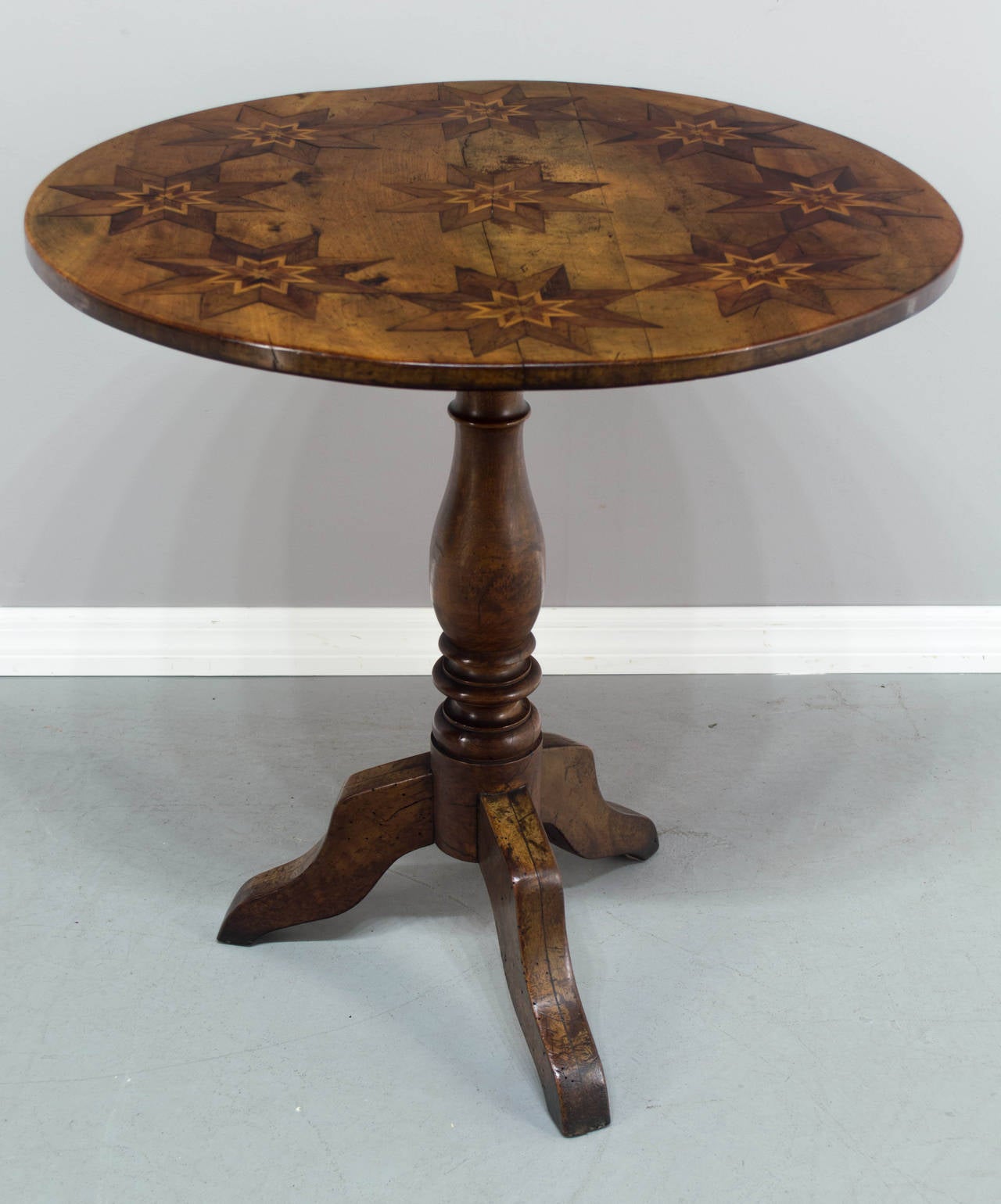 19th century Louis Philippe gueridon or tilt-top table, made of walnut with inlaid stars. Great craftsmanship. All original. French polish finish. Height when tilted: 45.5