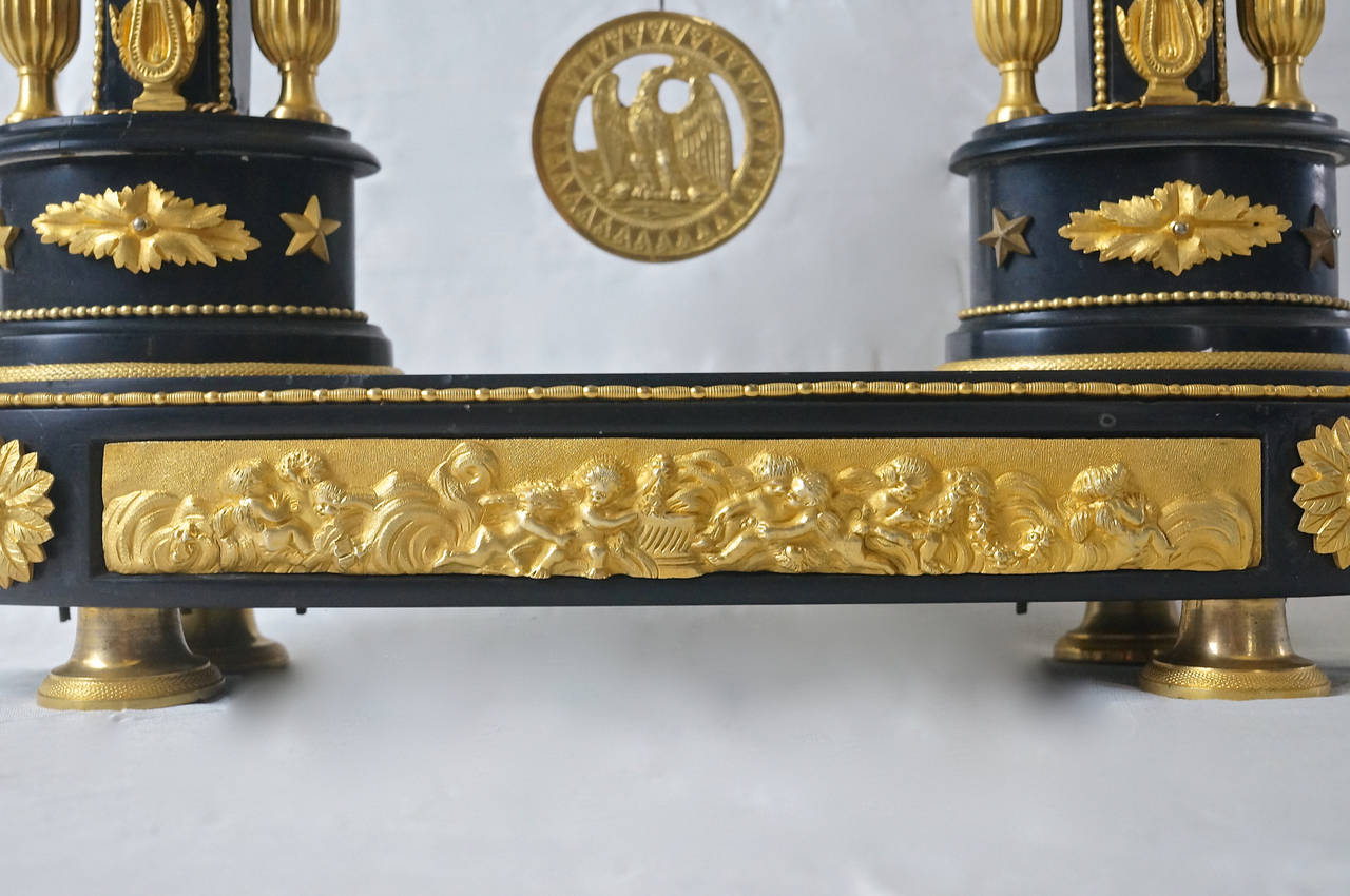 This striking Louis XVI mantel clock is constructed in black marble and doré patonized brass castings. Brass castings, both mounted and inlaid and turnings are of the highest quality. A Federal eagle is depicted at center of the pendulum,