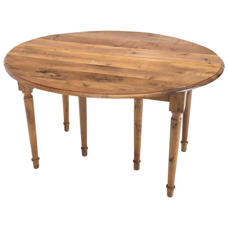 An oval walnut extension table with six turned legs and two leaves. Beautiful color and a great versatile size, expanding from 25.5