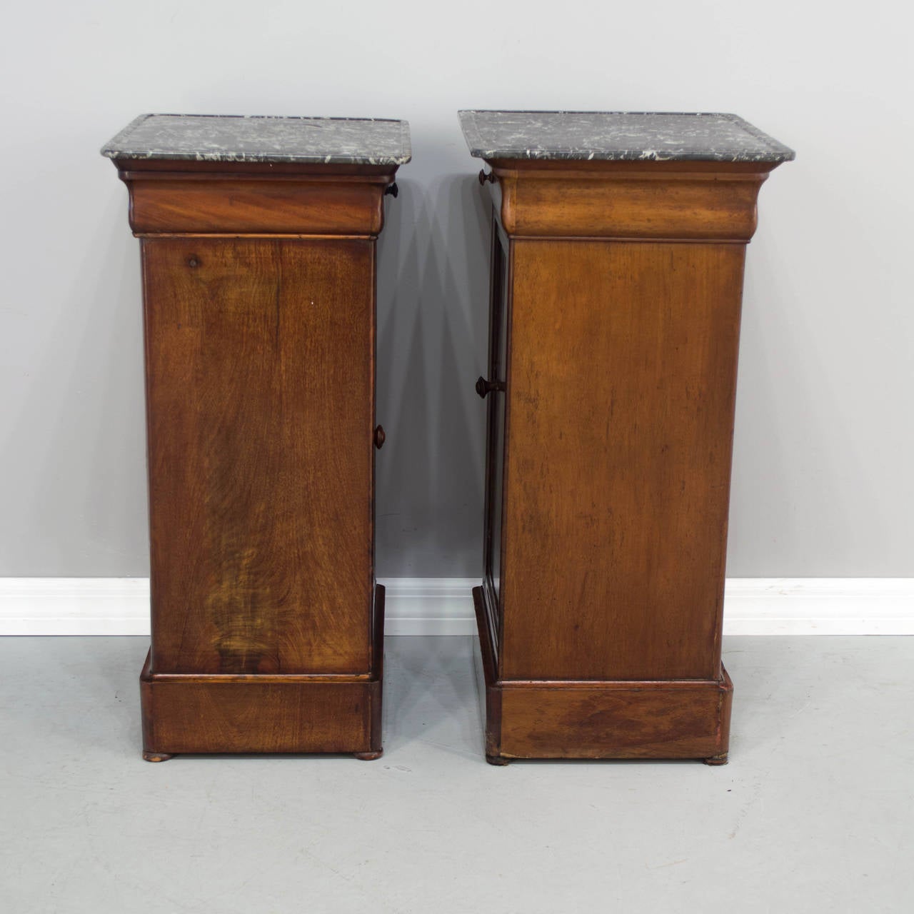 A 19th c. Similar Pair of Louis Philippe Night Tables made of veneer and solid Mahogany, each having a door below a drawer, topped with a grooves St Anne Marble top. The Left one is 29.5