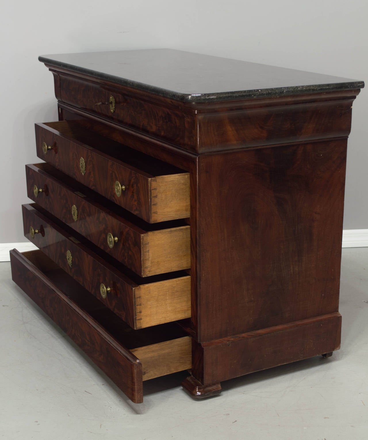 19th century Louis Philippe period mahogany commode having four dovetailed drawers and a top drawer that hinges down and pulls out to reveal a (newer) embossed leather writing surface. Desk with lock and key has four small dovetailed drawers with