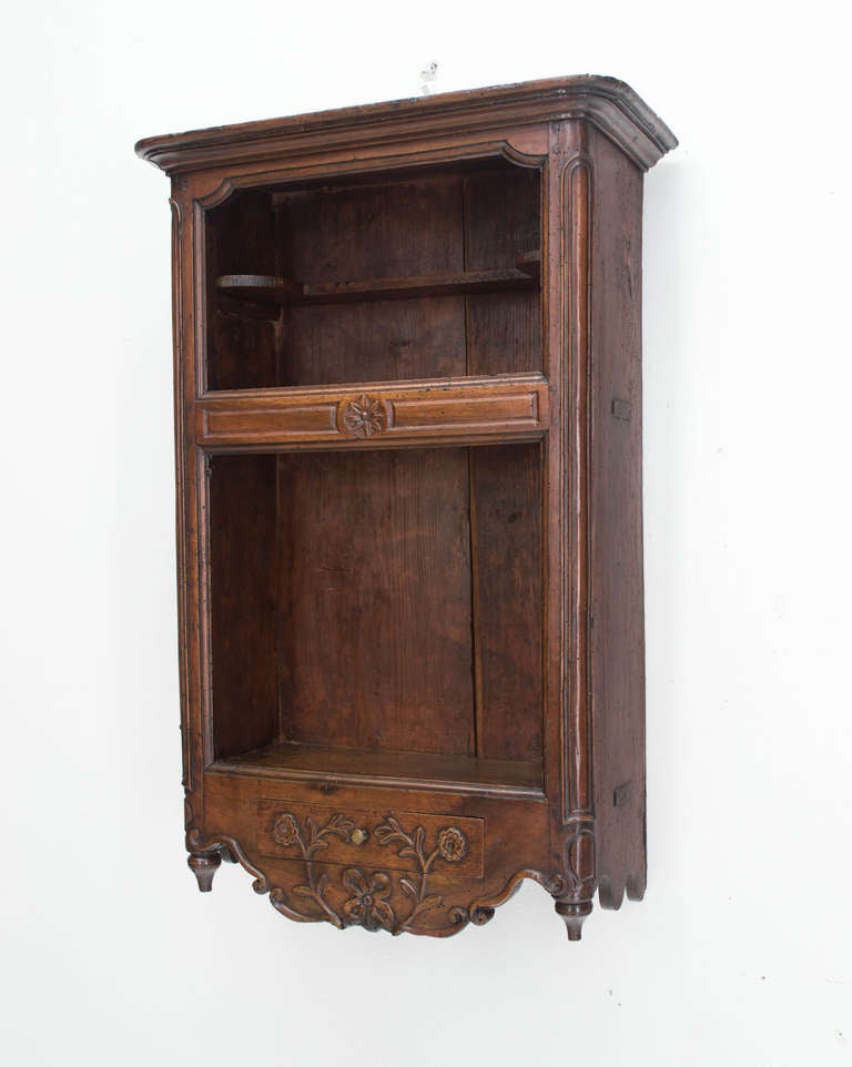 An original Estagnier, or shelf from Provence, made of walnut and pine as a secondary wood, with a drawer, hand carvings. This shelf was used in the kitchen to display some pewter.