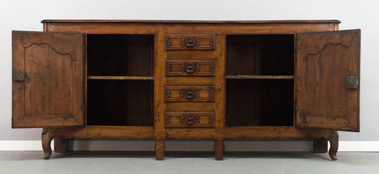 18th century country French enfilade, or sideboard from Picardie (Northern France) made of solid pear wood. Beautiful hand-carved details and raised panel doors. Great proportions and ample storage, with four center drawers and two doors opening to