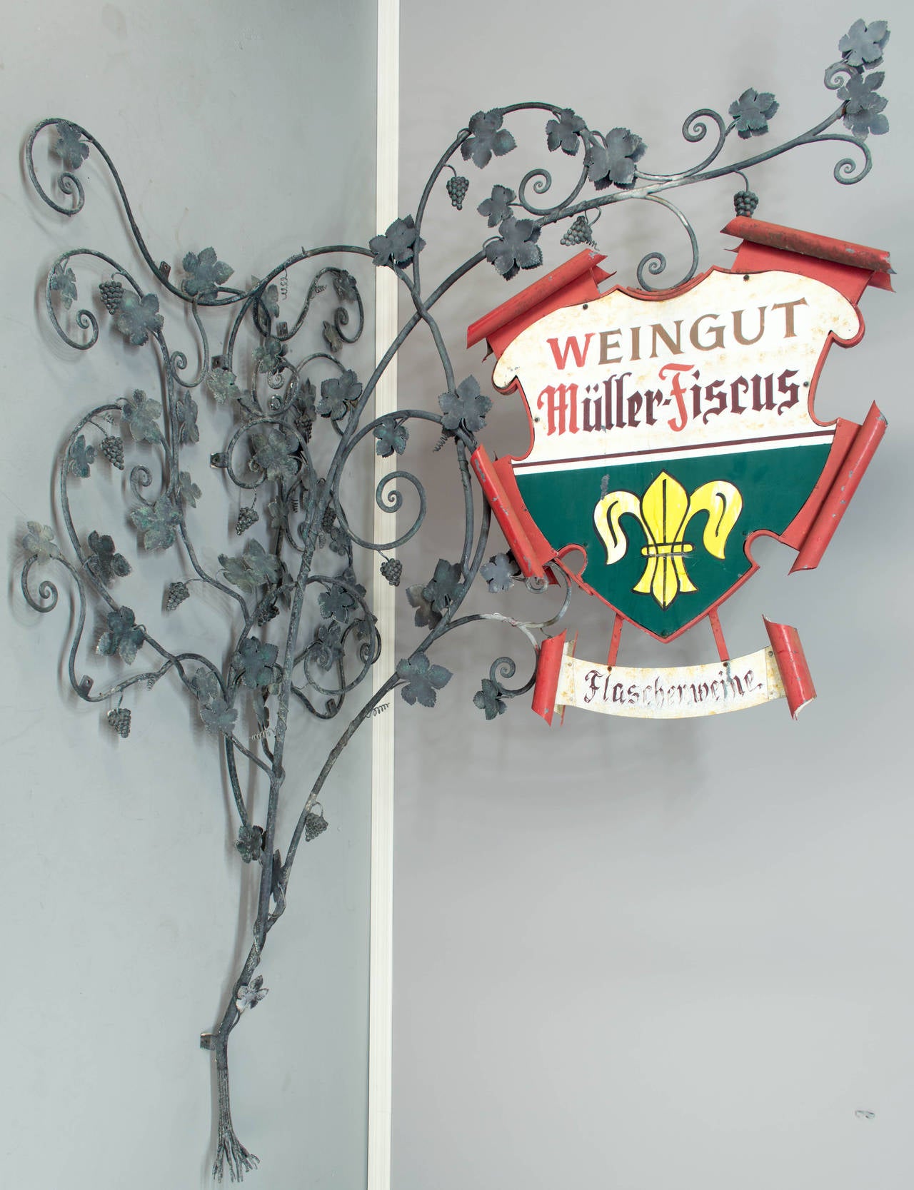A large wrought iron and metal sign from a winery in southern Germany near Alsace. Grape leaves and clusters of grapes are welded to the large wrought iron vine framework. Exceptional craftsmanship. The crest shaped painted sign is double-sided and