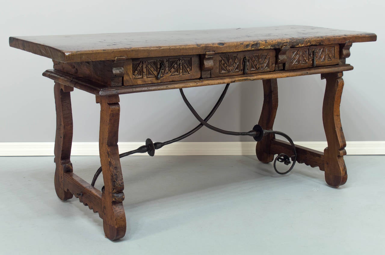 18th century Spanish Baroque walnut table desk with wrought iron trestle attached to wooden side stretchers. Exceptionally beautiful character to the wood of the single, 1-3/4