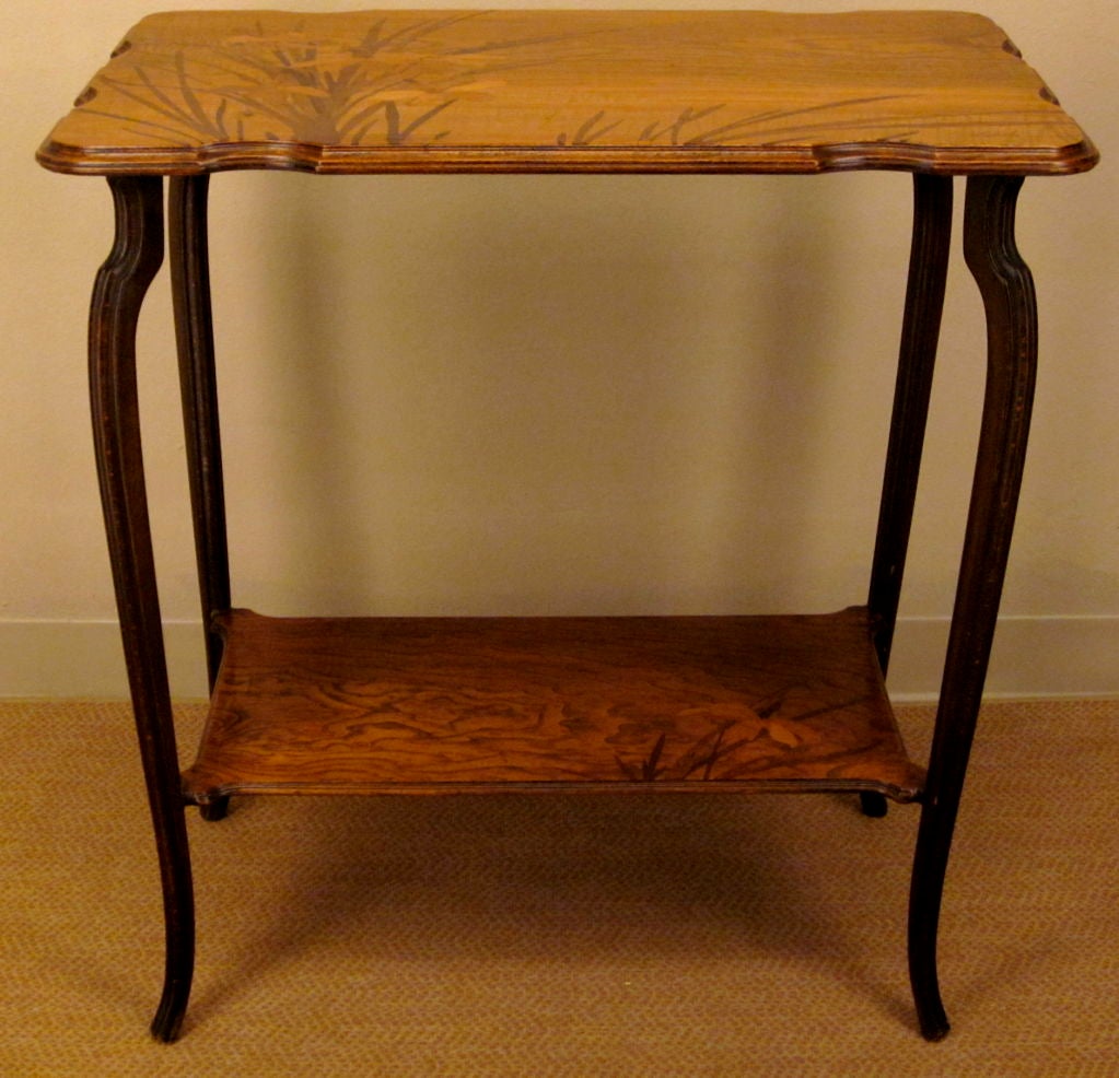 A French Art Nouveau two tier side table by Emile Gallé, featuring inlaid marquetry made of  a combination of rosewood, walnut and fruitwoods. The table is signed: 