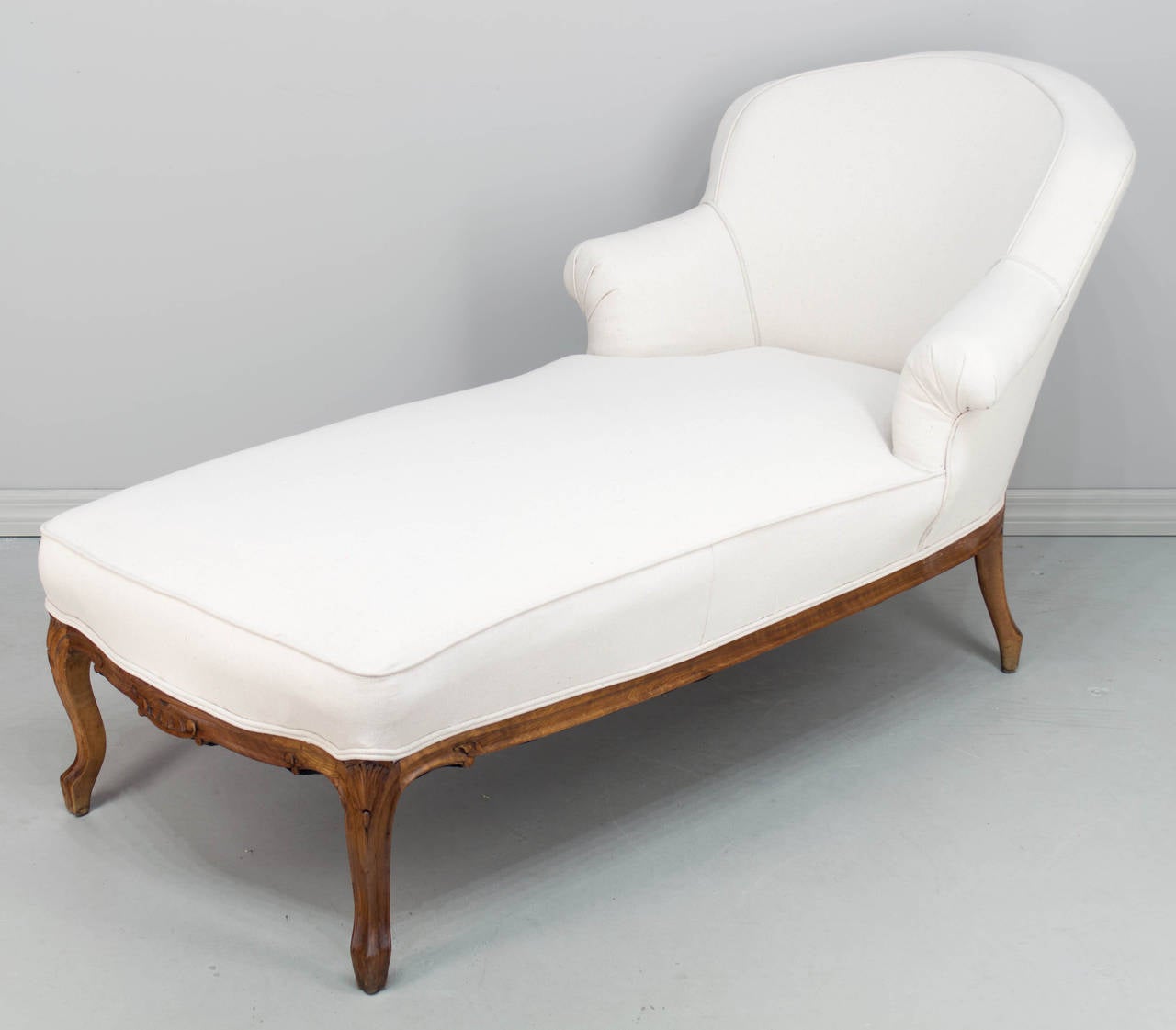Louis XV Style recamier or chaise longue with a walnut frame. Sturdy and comfortable. Reupholstered in a neutral canvas fabric. The seating area is 54