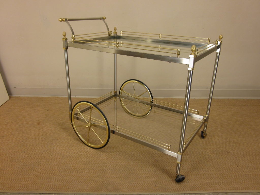 A great two tone brass and chrome two tiered cocktail trolley made by LaBarge with pineapple finials. Top shelf with a silver banding, original.