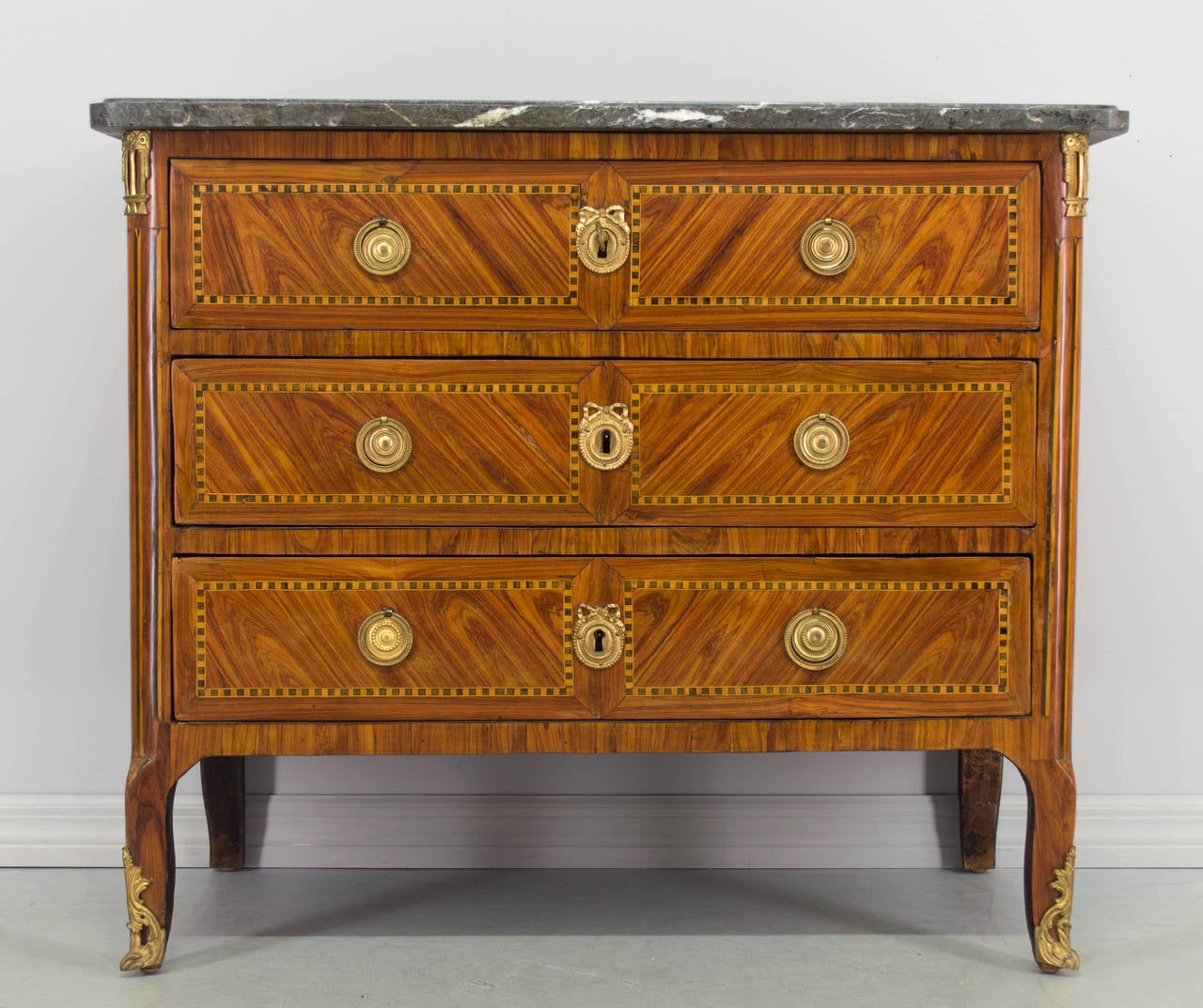 18th century Louis XVI marquetry commode or chest of drawers with tulipwood inlay veneer and oak and pine as secondary wood. Nice proportions and expert craftsmanship with vertical striped inlay on the curved front corners. Three dovetailed drawers