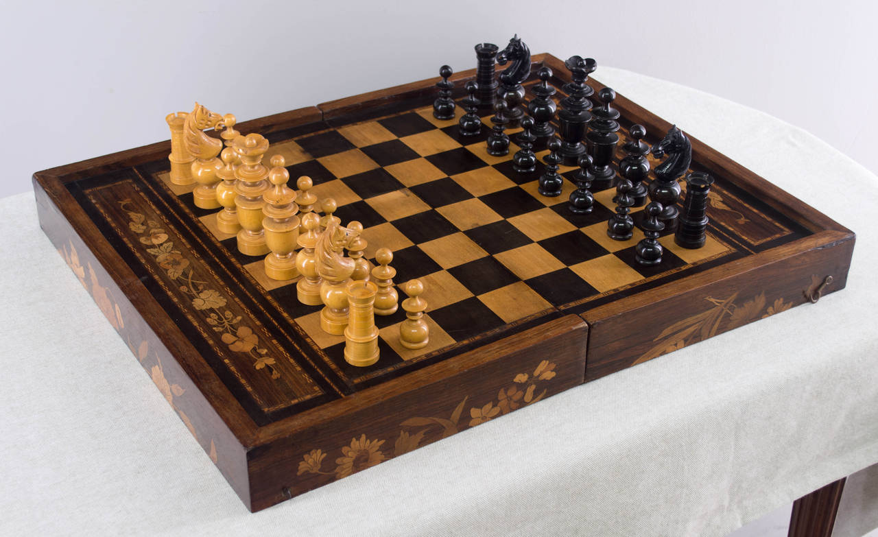 A complete 19th century French chess and backgammon set with inlaid game box that hinges open to reveal felt covered backgammon board. Box is made of veneers of walnut and rosewood with beautiful floral marquetry inlaid design. Turned and carved
